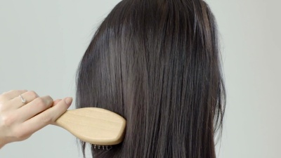 女人用发刷梳理长发