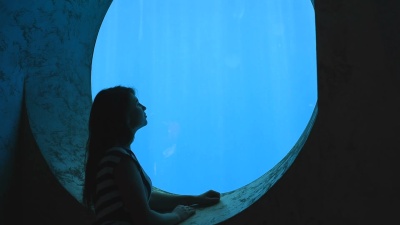 浪漫的女孩欣赏水族馆的水下世界