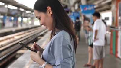 在火车站使用智能手机社交网络的女人
