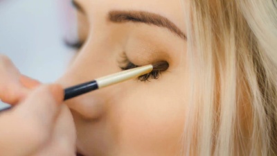 专业眼影化妆师涂抹眼影粉。漂亮的女人脸。完美的化妆。美容时尚。睫毛。特写