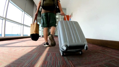 带着行李通过机场候机楼的男子旅行者