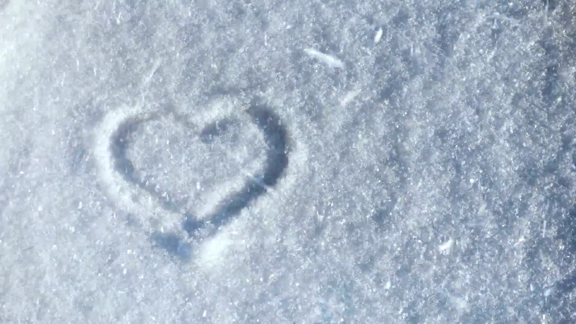 心的象征在雪上，许多雪花在风中飞舞