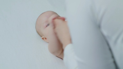 父母牵着新生儿的手