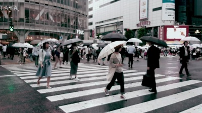 下雨时穿过城市道路的人群