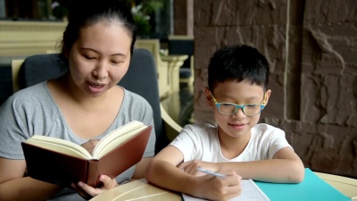 男孩和妈妈在桌子上做作业