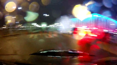 快速城市驾驶夜间道路POV挡风玻璃和引擎盖，雨夜，雨滴落在玻璃上