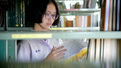 亚裔女生在公共图书馆读书