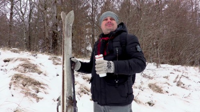 在户外带着滑雪板和保温瓶的男人