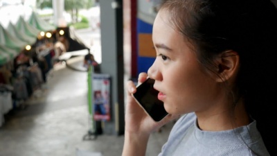 年轻女子在自动扶梯上使用智能手机