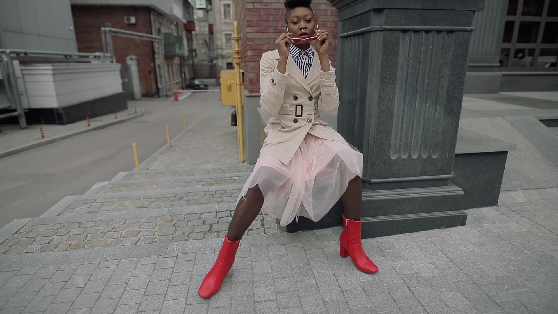 Stylish fashionable woman blogger sitting in urban city