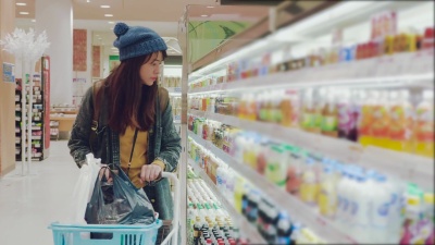 年轻女子在商店里选择乳制品