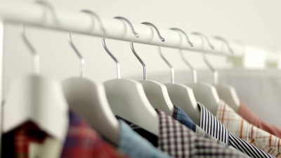 男士衬衫店。男人的手在衣柜里选择衬衫。