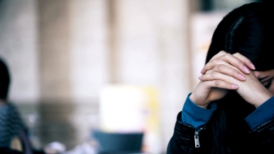 关闭照片悲伤和焦虑的亚洲妇女坐在酒吧-户外