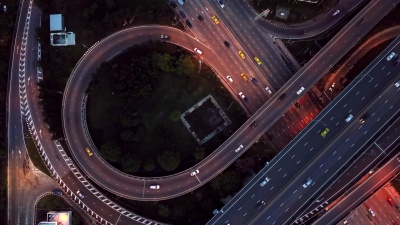 鸟瞰高速公路立交桥，夜间繁忙的城市交通在道路上超速行驶