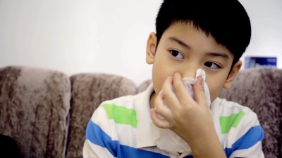 小亚洲小孩患流感打喷嚏并用卫生纸清洁