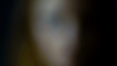 美丽的女孩在模糊的背景下看着相机