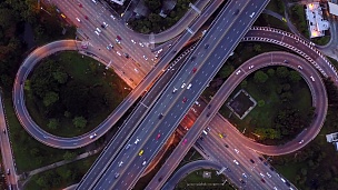 鸟瞰无限公路立交桥，夜间繁忙的城市交通在道路上超速行驶