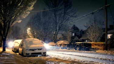 在暴风雪的夜晚，汽车经过房屋