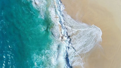 由 无人机拍摄的海浪撞击海滩的鸟瞰。