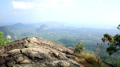 日落山峰悬崖上的女性徒步旅行者