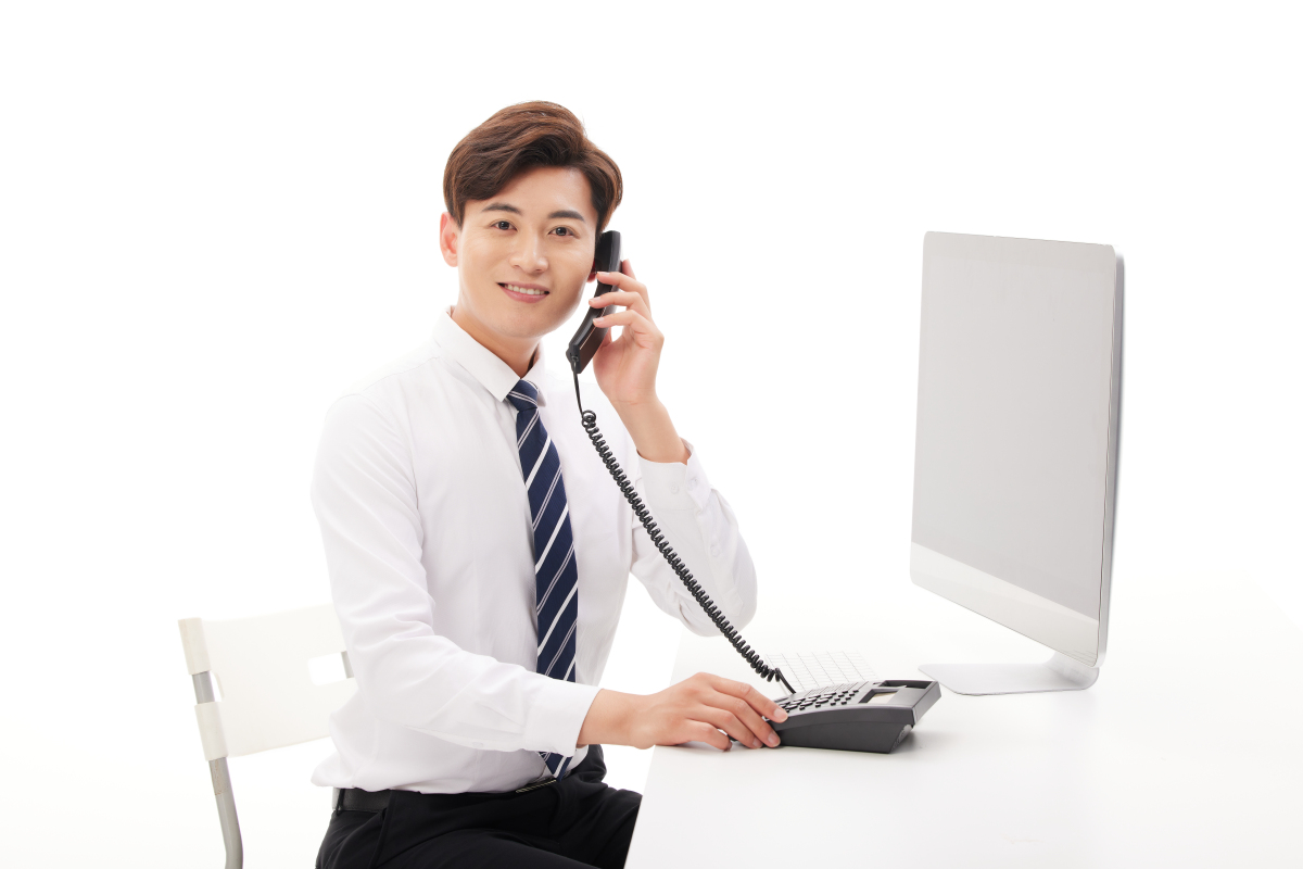 人物系列年轻男性坐在电脑前的桌上打电话