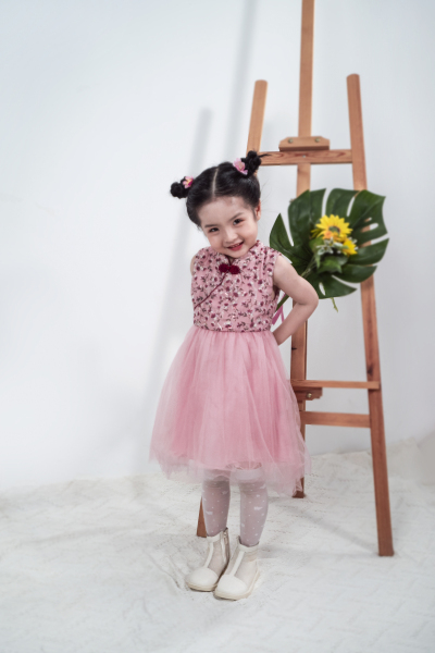 服饰系列穿着粉色无袖绣花连衣裙站在画架前的小女孩