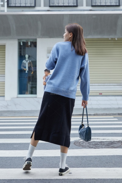 服饰系列实景模特穿着蓝色毛衣和黑色长裤的室外摆拍   