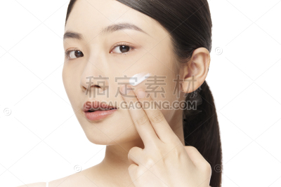 美妆系列写实试用美容产品的年轻女性