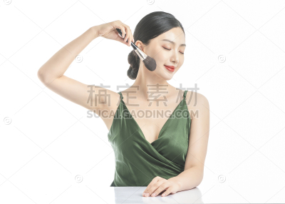 美妆系列写实穿着墨绿色v领裙子使用化妆刷的美妆模特半身照