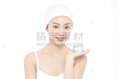 美妆系列写实穿着白色吊带戴着白色干发毛巾展示化妆品的年轻女性白底半身照