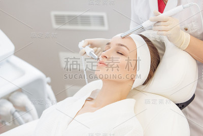 美容师在一个女孩客户脸上做微电流治疗