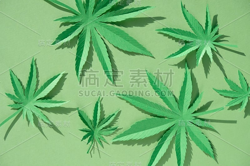 在绿色背景上用纸制成的大麻叶子