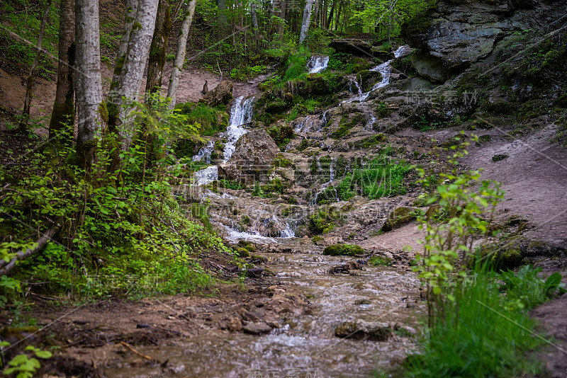 美丽的高山雨林瀑布与快速流动的水和岩石，长时间暴露。自然季节性的户外旅游背景与阳光时兴