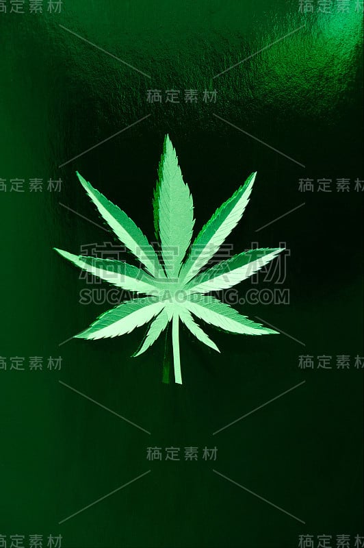 在绿色背景上用纸制成的大麻叶子