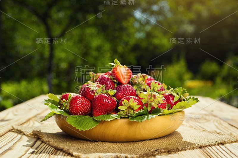 草莓篮子放在自然背景的木桌上，美味的一级有机水果作为夏季维生素概念