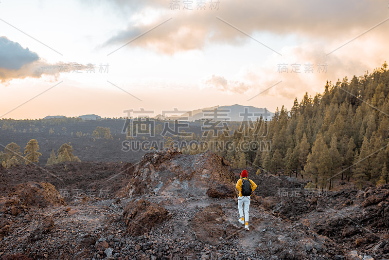 日落时分在火山上旅行的女人