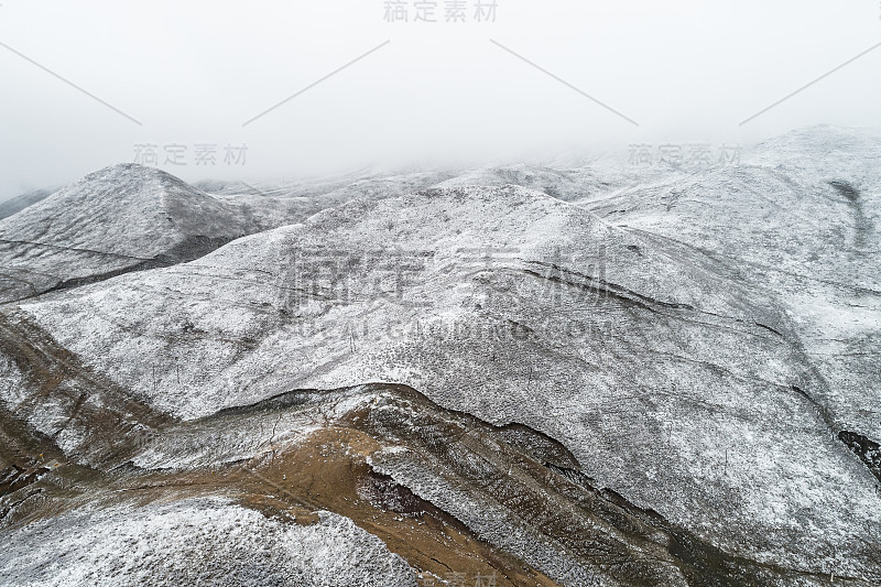 蜿蜒穿过被雪山环绕的山谷的乡村道路