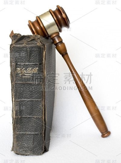 垂直的古董皮革圣经与木槌在白色的背景