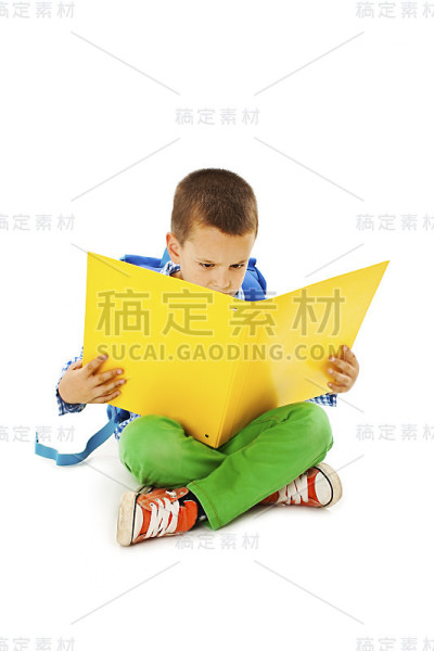 小男孩在读一本黄色的大书