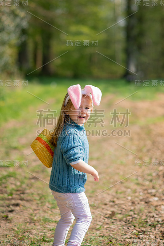 有兔耳朵的女孩为复活节收集巧克力蛋