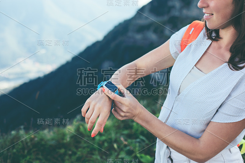 在山里旅行的女人在看智能手表