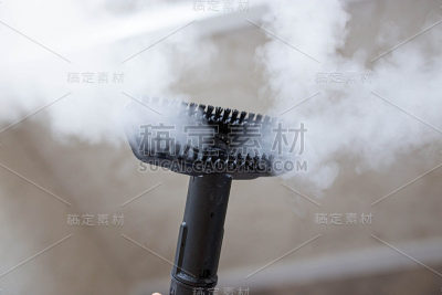 蒸汽清洁器用于清洁房屋，蒸汽从刷子上喷涌而出。