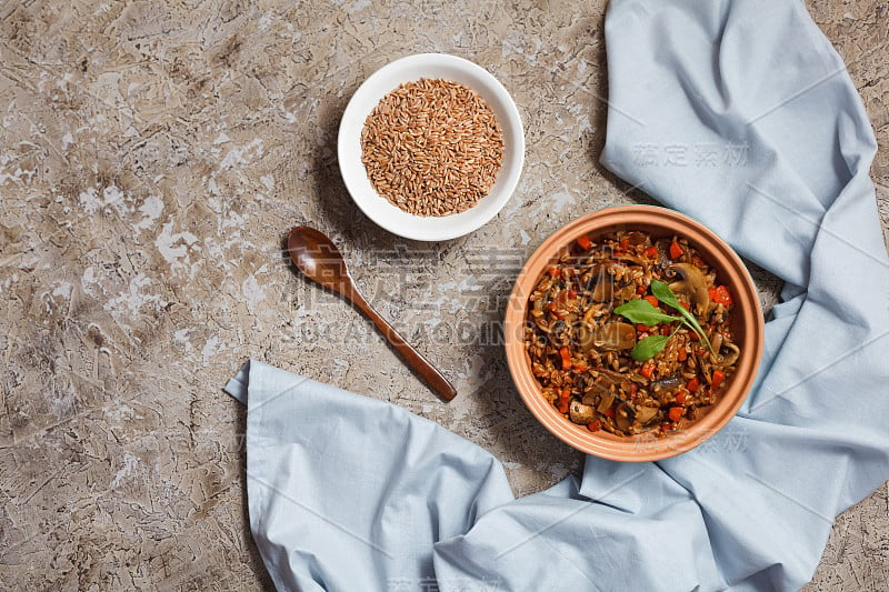 与蘑菇，胡萝卜和香料在一个粘土盘子在纹理的背景。