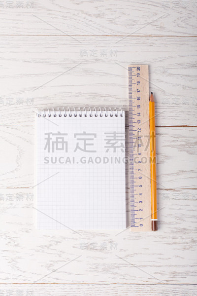 桌上放着带铅笔和尺子的记事本