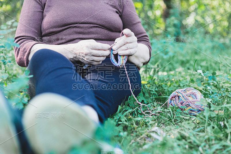 Close-up shot of senior woman knitting in nature