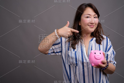 工作室拍摄的成熟美丽的亚洲女商人在灰色的背景
