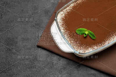 传统的意大利提拉米苏甜点在玻璃烤盘在混凝土背景