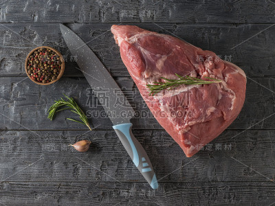 木桌上放着一把大刀和一大块猪肉。从上往下看。