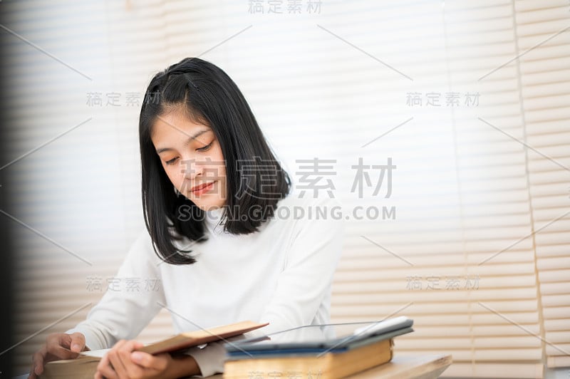 一位穿着白衬衫的亚洲女学生坐在大学里读书