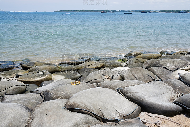 海滩上的一排沙袋，保护海岸免受海浪的破坏